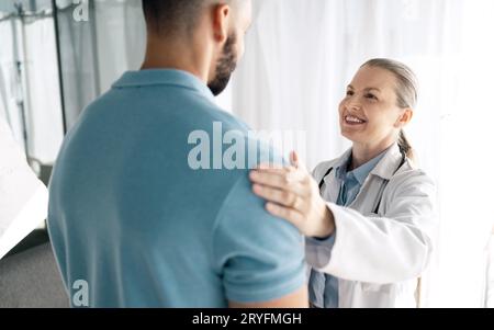 Arzt, Patient und Frau berühren Schulter für Unterstützung in Beratung für Gesundheit, Wellness oder Empathie. Glücklicher medizinischer professioneller Komfort-Mann für Stockfoto