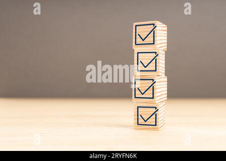 Prüf- oder Checklisten-Konzept. Holzklotz mit Karotz-Symbol auf Holztisch gestapelt. Speicherplatz kopieren Stockfoto