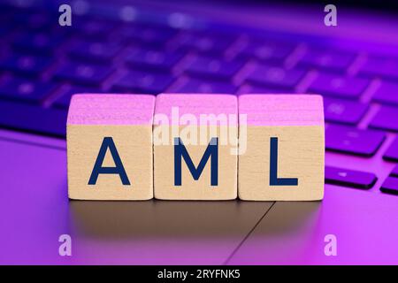 AML-Wort auf Holzblöcken auf dem Laptop mit bunten Lichtern. Konzept zur Verhinderung von Geldwäsche Stockfoto