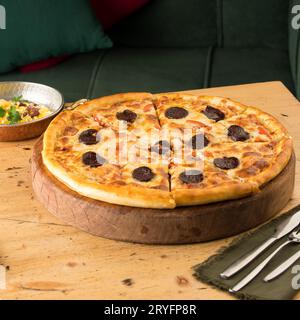 Nahaufnahme von frisch gebackener Pizza auf einem Tisch Stockfoto