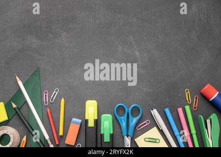 Zurück zum Schulhintergrund mit Kopierplatz. Verschiedene Büro- und Schulmaterialien mit Blackboard-Hintergrund Stockfoto
