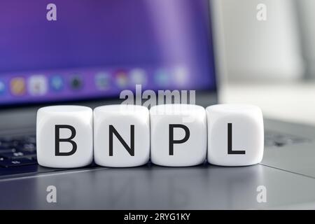 BNPL oder Buy Now Pay Later Konzept. Text auf Cube-Blöcken auf Laptop Stockfoto