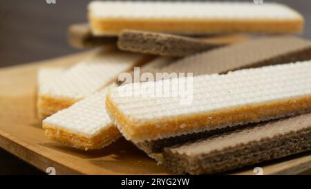 Käsescheiben und Schokoladenscheiben werden auf einem Holzteller auf einem Holztisch serviert Stockfoto