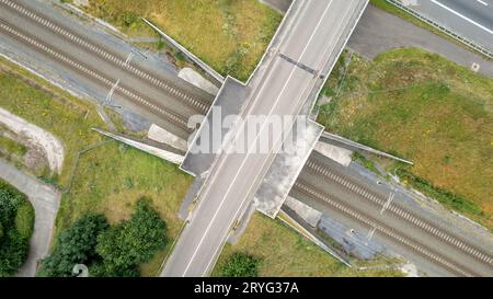 Luftaufnahme auf eine Autobahn und eine Eisenbahn. Clip. Autobahn und Eisenbahn mit Autos und Lastwagen, Kreuzung, zweistöckige Straßenkreuzung in der Th Stockfoto