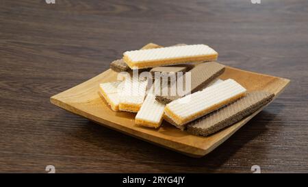 Käsescheiben und Schokoladenscheiben werden auf einem Holzteller auf einem Holztisch serviert Stockfoto