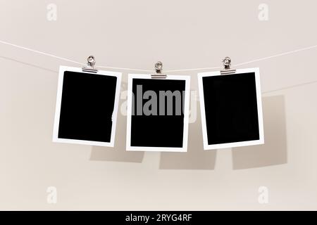 Three Blank Vintage Instant Bilderrahmen, der an einem Seil hängt. Vorlage Stockfoto