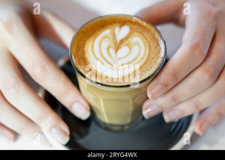 Aromatische Tasse Kaffee in weiblichen Händen, Großansicht von oben Stockfoto