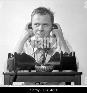 In den 1950er Jahren Sixten Larsson mit zwei Telefonen, die beschäftigt