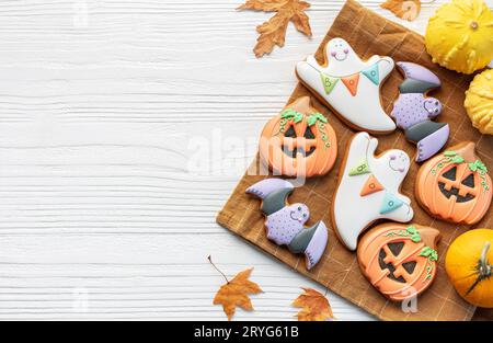 Bunte selbstgemachte Halloween-Kekse auf weißem hölzernem Hintergrund. Stockfoto