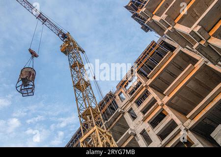 Eine Tiefwinkelaufnahme eines Krans mit Ausrüstung auf einer Baustelle mit neuer Gebäudeinfrastruktur. Beton in einen Mo gießen Stockfoto