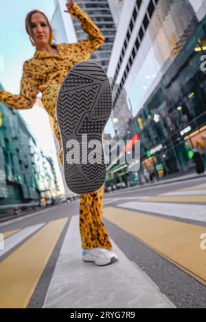 Eine schöne Aufnahme einer Frau in Gelb, die ihre Ferse hebt, und der Stadt Moskau im Hintergrund Stockfoto