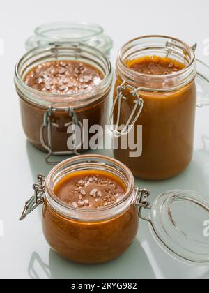 Gesalzenes Karamell in Glasgefäßen. Vertikal Stockfoto