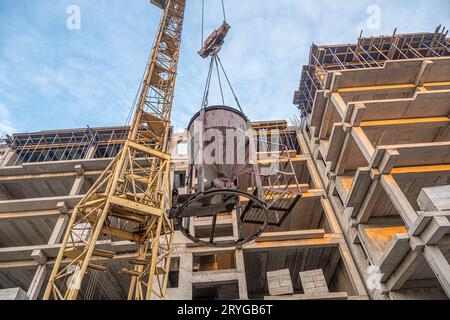 Eine Tiefwinkelaufnahme eines Krans mit Ausrüstung auf einer Baustelle mit neuer Gebäudeinfrastruktur. Beton in einen Mo gießen Stockfoto