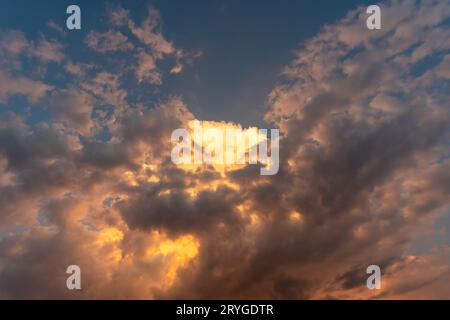 Perfekter Hintergrund helle goldorange Wolken, die von Sonnenlicht beleuchtet werden. Sommerabend mit hellem Himmel, der Ihre Fotos überlagert Stockfoto