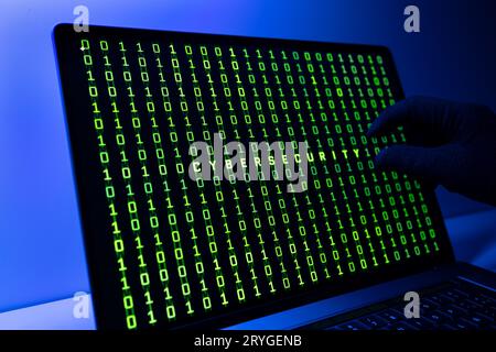 Sicherheitskonzept Ciber. Handschaufel, Binärcode und Cybersecurity-Wort auf Laptop-Computer-Bildschirm Stockfoto