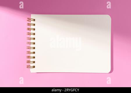 Leeres Notizbuch aus weißem Papier, isoliert auf rosa Hintergrund. Mustervorlage Stockfoto