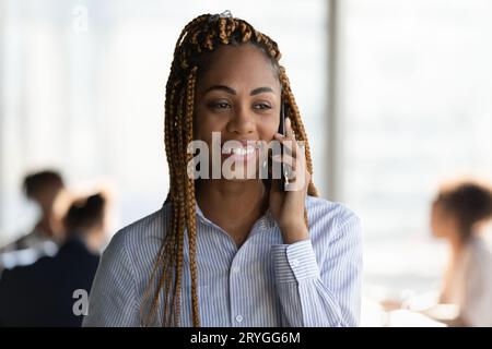 Kopfschuss lächelnder afroamerikanischer Geschäftsmann, der telefoniert Stockfoto