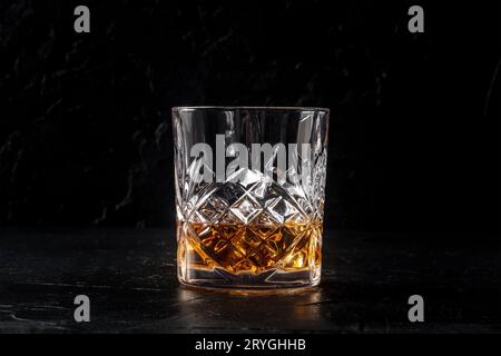 Whiskey in einem Glas mit Eis, Bourbon Whisky auf Felsen auf schwarzem Schiefergrund Stockfoto