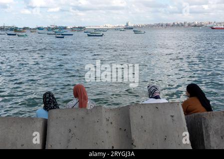 Alexandria, Ägypten. Dezember 2022. Ägyptische muslimische Frauen sitzen auf großen Betonblöcken, die Überschwemmungen aufgrund des durch die globale Erwärmung verursachten Meeresspiegelanstiegs verhindern sollen. (Foto: John Wreford/SOPA Images/SIPA USA) Credit: SIPA USA/Alamy Live News Stockfoto