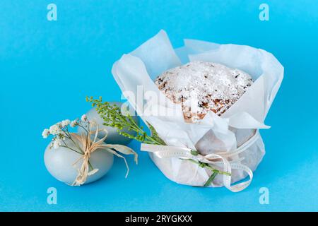 Traditioneller Osterkuchen, farbiges Ei mit Blume auf blauem Hintergrund Stockfoto