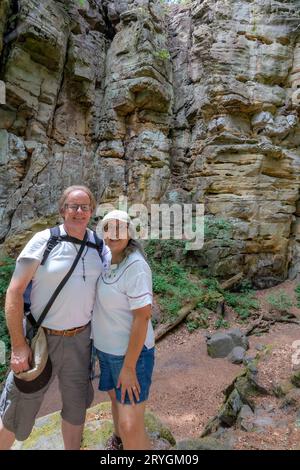 Seniorenpaar lächelnde Wanderer mit Berghang oder Felswand im Hintergrund, die Wanderroute zwischen dem Naturschutzgebiet Teufelsschlucht erkunden Stockfoto