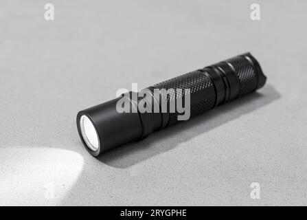 Moderner LED-Taschenlampenschalter aus Aluminium, isoliert auf grauem Hintergrund Stockfoto