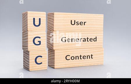 UGC nutzergenerierter Content Text auf Holzblöcken auf grauem Hintergrund Stockfoto