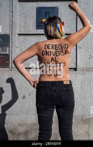 Madrid, Spanien. Oktober 2023. Eine Aktivistin der feministischen Gruppe FEMEN zeigt auf ihrem Rücken eine Botschaft mit der Aufschrift "universelles Recht auf Abtreibung", die vor der Botschaft von Andorra in Madrid protestiert. FEMEN-Aktivisten fordern die Entkriminalisierung der Abtreibung im Land Andorra. Quelle: Marcos del Mazo/Alamy Live News Stockfoto