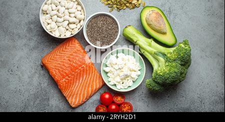 Auswahl gesunder Nahrungsmittel, wenn eine Person Diabetes hat: Lachsfisch, Brokkoli, Avocado, Bohnen, Gemüse, Samen auf grauem B Stockfoto