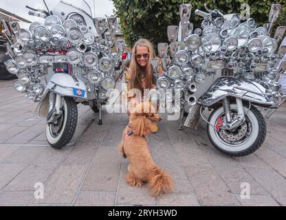 London, Großbritannien. Oktober 2023. Lisa mit ihrem Pudel Nancy steht neben zwei Mods Scootern beim Oldtimer Booth Sale in London - 30. September-1. Oktober 2023.Paul Quezada-Neiman/Alamy Live News Credit: Paul Quezada-Neiman/Alamy Live News Stockfoto