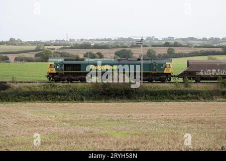 Diesellokomotive der Baureihe 66 von Freightliner, die einen Güterzug auf der West Coast Main Line, Northamptonshire, England, zieht Stockfoto