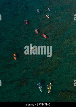 Gruppe von Sportlern, Kajakfahren im Meer. Menschen aktiv Stockfoto