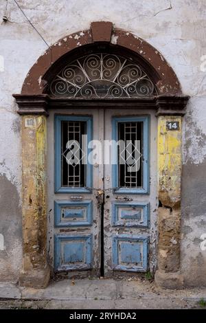 Traditionelle Vintage geschlossene blaue Holztür vor einem abgerissenen Haus. Verlassene Häuser. Stockfoto