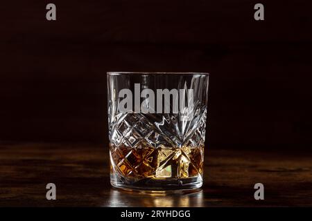 Whiskey in einem Glas mit Eis, Bourbon Whisky auf Felsen auf dunklem Hintergrund Stockfoto