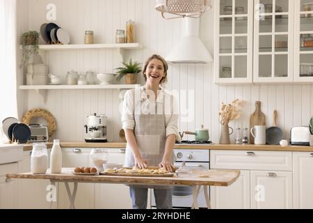 Porträt der glücklichen Hausfrau in der Schürzenkoche in der Küche Stockfoto