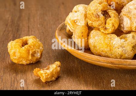 Nahaufnahme der hausgemachten knusprigen, köstlichen frittierten Schweineschalen auf Holzteller. Stockfoto