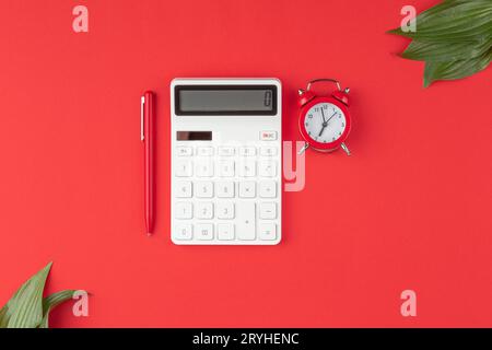 Stift mit Taschenrechner, Wecker auf rotem Hintergrund Stockfoto