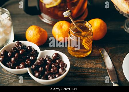 Honig im Glas mit hölzernem Honiglöffel auf einem Serviertisch Stockfoto