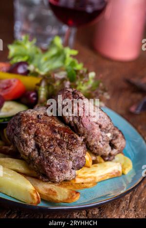griechischer Bifteki mit Salat und Pommes frites Stockfoto