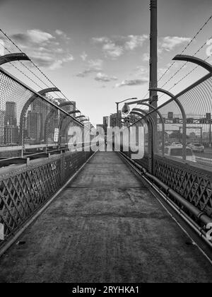 Schwarzweiß-Foto des Fußgängerwegs mit Blick auf das Stadtzentrum auf der berühmten Sydney Harbour Bridge, NSW, Australien Stockfoto