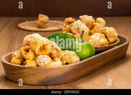 Haufen hausgemachter knuspriger, frittierter Schweineschalen in Holztablett. Stockfoto