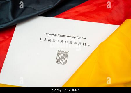 Augsburg, Bayern, Deutschland. September 2023 29. Dokumente zur Landtagswahl in Bayern am 8. Oktober 2023 unter deutscher Flagge. Stimmpapierumschlag zur Landtagswahl in Bayern *** Unterlagen zur Landtagswahl am 8. Oktober 2023 auf einer Deutschland Flagge. Stimmzettel Umschlag zur Landtagswahl Credit: Imago/Alamy Live News Stockfoto