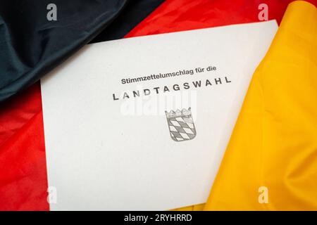Augsburg, Bayern, Deutschland. September 2023 29. Dokumente zur Landtagswahl in Bayern am 8. Oktober 2023 unter deutscher Flagge. Stimmpapierumschlag zur Landtagswahl in Bayern *** Unterlagen zur Landtagswahl am 8. Oktober 2023 auf einer Deutschland Flagge. Stimmzettel Umschlag zur Landtagswahl Credit: Imago/Alamy Live News Stockfoto