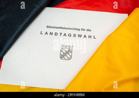 Augsburg, Bayern, Deutschland. September 2023 29. Dokumente zur Landtagswahl in Bayern am 8. Oktober 2023 unter deutscher Flagge. Stimmpapierumschlag zur Landtagswahl in Bayern *** Unterlagen zur Landtagswahl am 8. Oktober 2023 auf einer Deutschland Flagge. Stimmzettel Umschlag zur Landtagswahl Credit: Imago/Alamy Live News Stockfoto