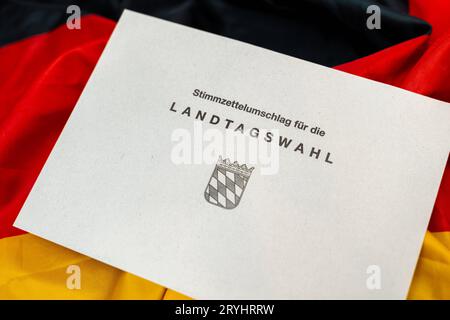 Augsburg, Bayern, Deutschland. September 2023 29. Dokumente zur Landtagswahl in Bayern am 8. Oktober 2023 unter deutscher Flagge. Stimmpapierumschlag zur Landtagswahl in Bayern *** Unterlagen zur Landtagswahl am 8. Oktober 2023 auf einer Deutschland Flagge. Stimmzettel Umschlag zur Landtagswahl Credit: Imago/Alamy Live News Stockfoto
