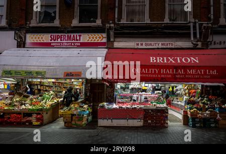Brixton, London, Großbritannien: Electric Avenue in Brixton bei Nacht. Ein multikulturelles Viertel von London mit internationalen Lebensmittelgeschäften und Lage des Brixton Market. Stockfoto
