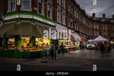 Brixton, London, Großbritannien: Electric Avenue in Brixton bei Nacht. Ein multikulturelles Viertel von London mit internationalen Lebensmittelgeschäften und Lage des Brixton Market. Stockfoto
