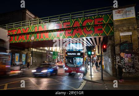 Brixton, London, Großbritannien: Eisenbahnbrücke über die Brixton Road an der Kreuzung mit der Atlantic Road in der Nähe des Bahnhofs Brixton. Bleiben Sie In Frieden. Stockfoto