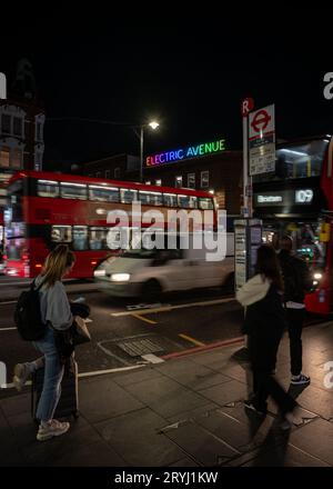 Brixton, London, Großbritannien: Leute, die an einer Bushaltestelle auf der Brixton Road gegenüber der Electric Avenue warten. Stockfoto