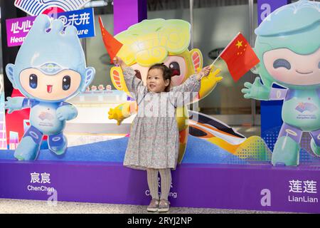 Peking, China. Oktober 2023. Ein Mädchen weht chinesische Nationalflaggen am Hongqiao Bahnhof in Shanghai, Ostchina, 1. Oktober 2023. Die Menschen im ganzen Land genießen sich am ersten Tag des Nationalfeiertags auf verschiedene Weise. Quelle: Wang Xiang/Xinhua/Alamy Live News Stockfoto